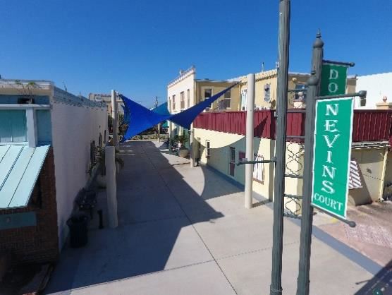 Low aerial photo looking down through a courtyard, with a sign that reads Nevins Court.