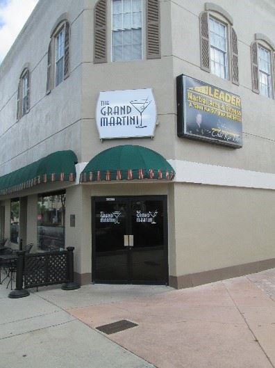 Photo of a corner building with a sign that says The Grand Martini.