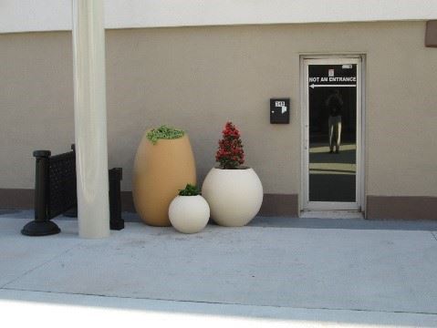 Photo showing three distinctly-shaped planters in a courtyard.
